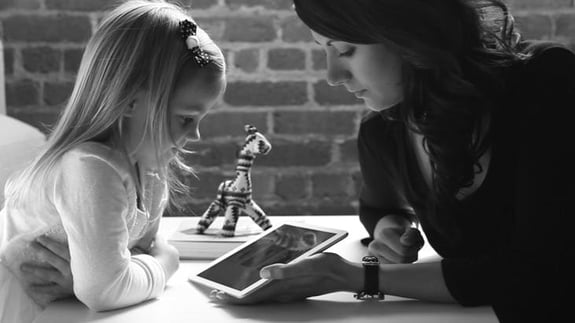 woman showing a little girl a tablet, Auteachism app by SF AppWorks concept bw